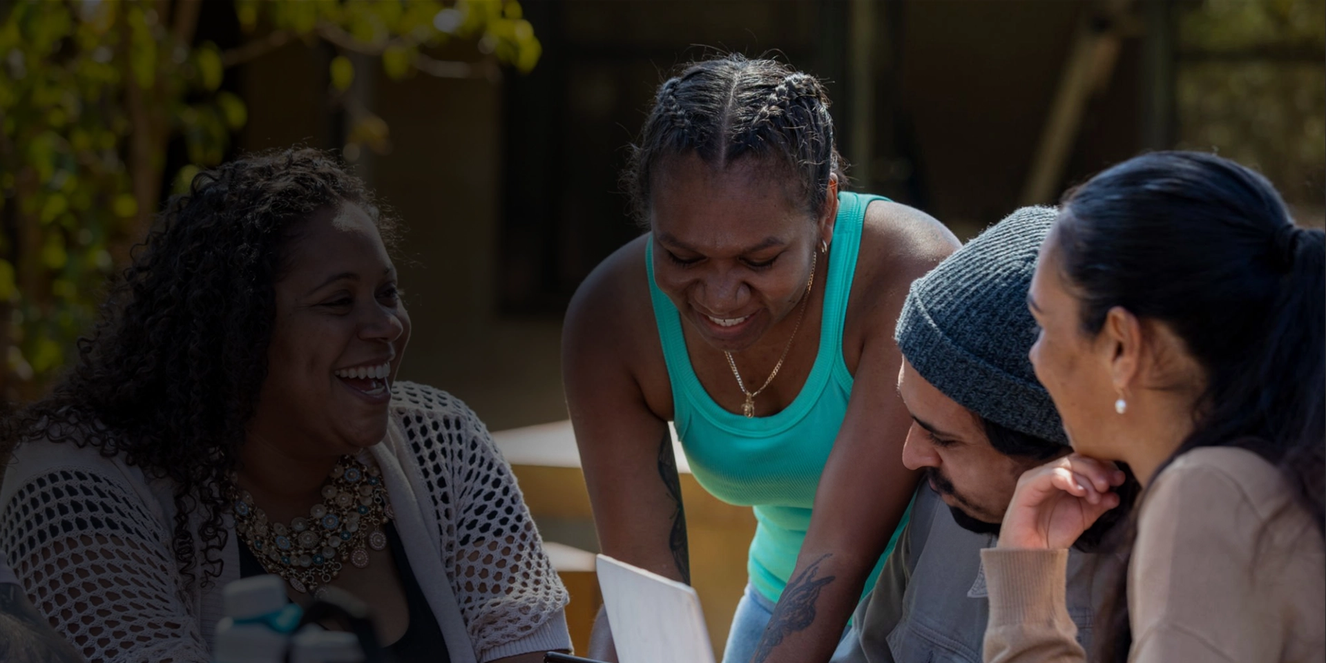 Three graduating indigenous Australians celebrating in academic regalia clothing